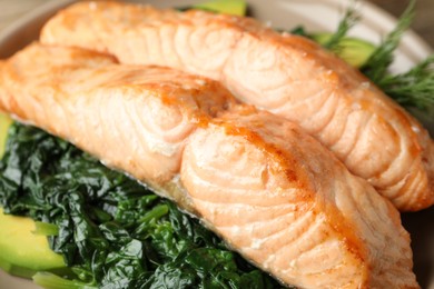 Photo of Tasty salmon with spinach and avocado on plate, closeup