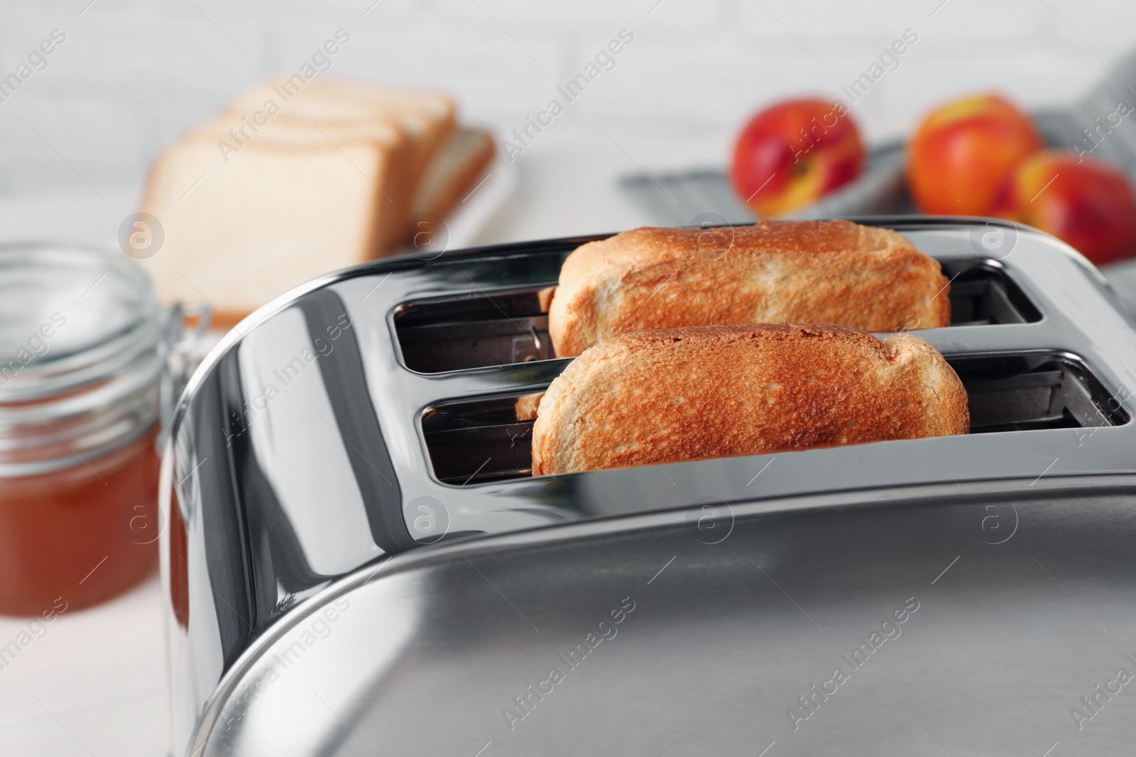 Photo of Tasty roasted bread in toaster indoors, closeup