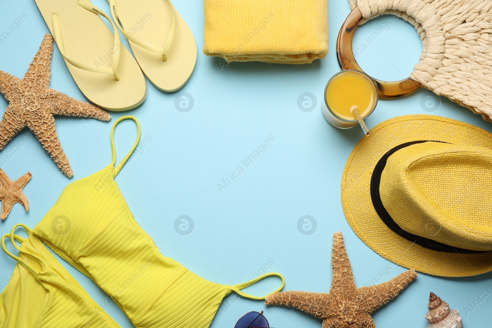 Photo of Frame of different beach objects on light blue background, flat lay. Space for text