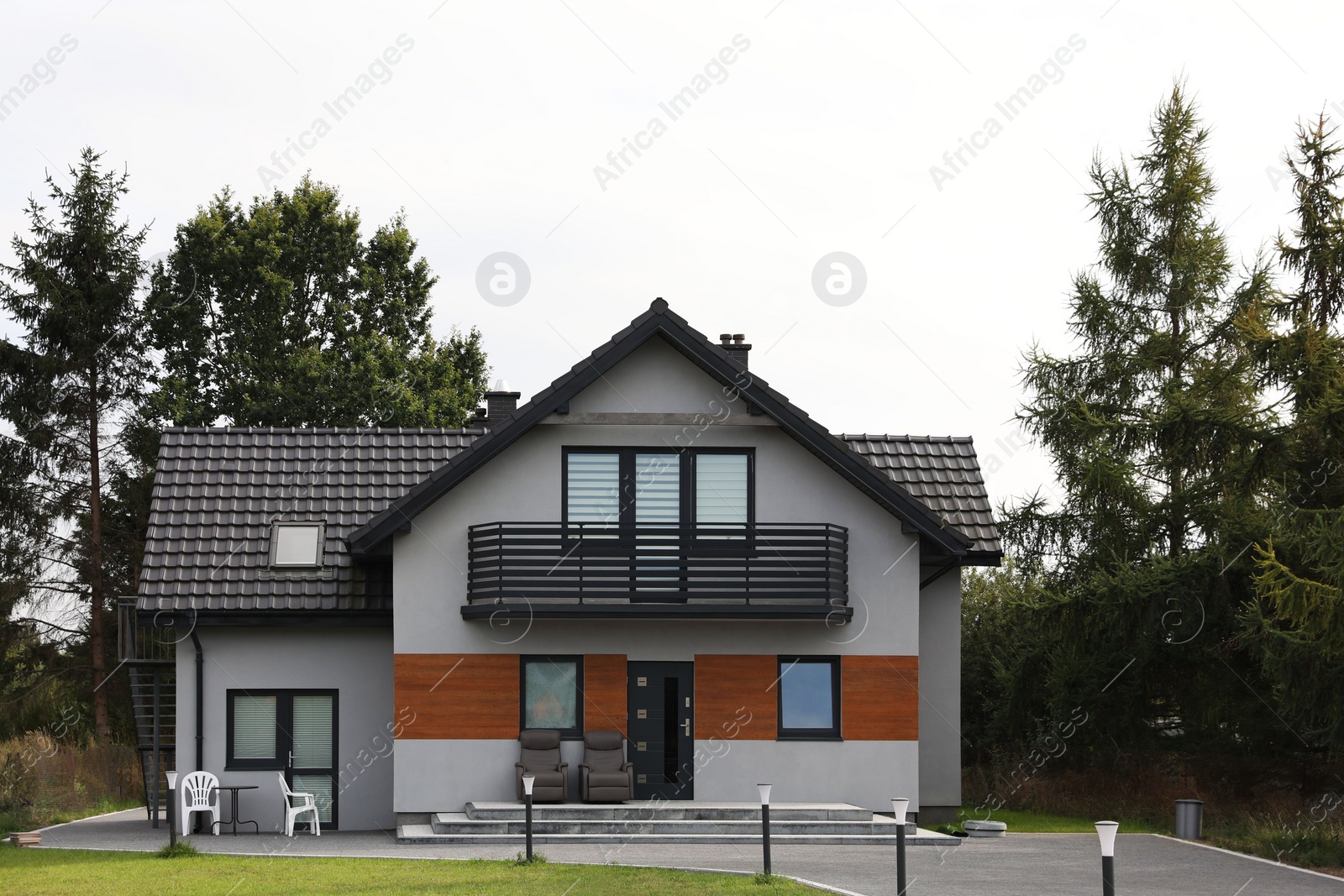 Photo of Beautiful beach house with balcony and trees outdoors