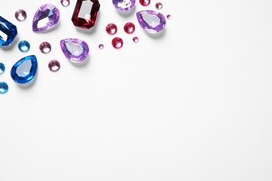 Photo of Different beautiful gemstones on white background, top view