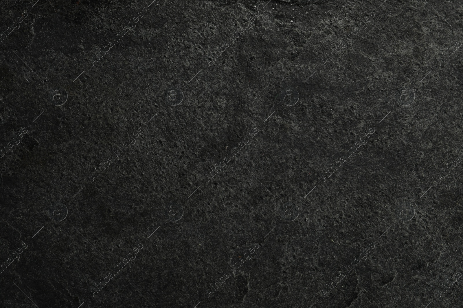 Photo of Texture of dark grey stone surface as background, closeup