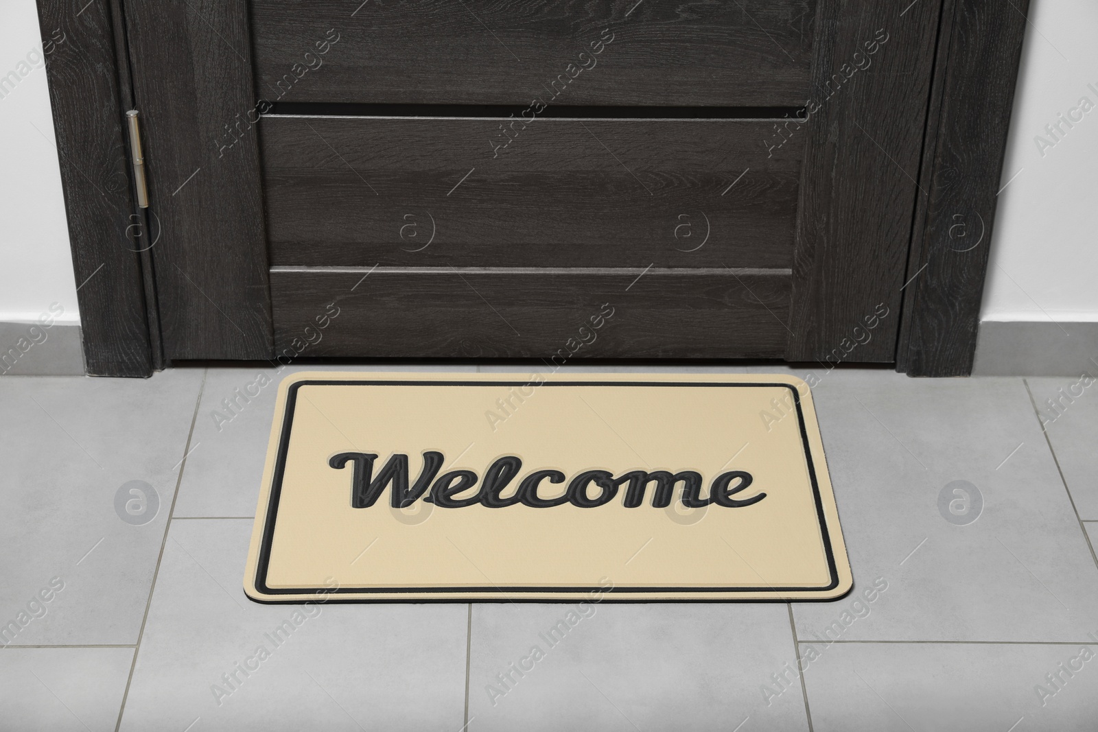 Photo of Beautiful beige doormat with word Welcome on floor near entrance