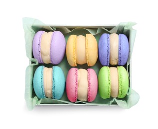 Photo of Many delicious colorful macarons in box on white background, top view