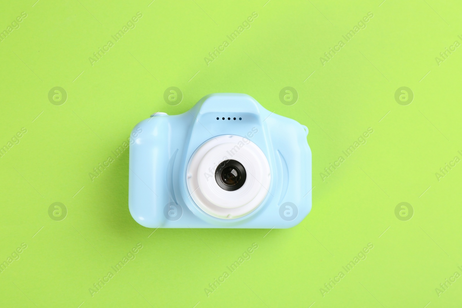 Photo of Light blue toy camera on green background, top view
