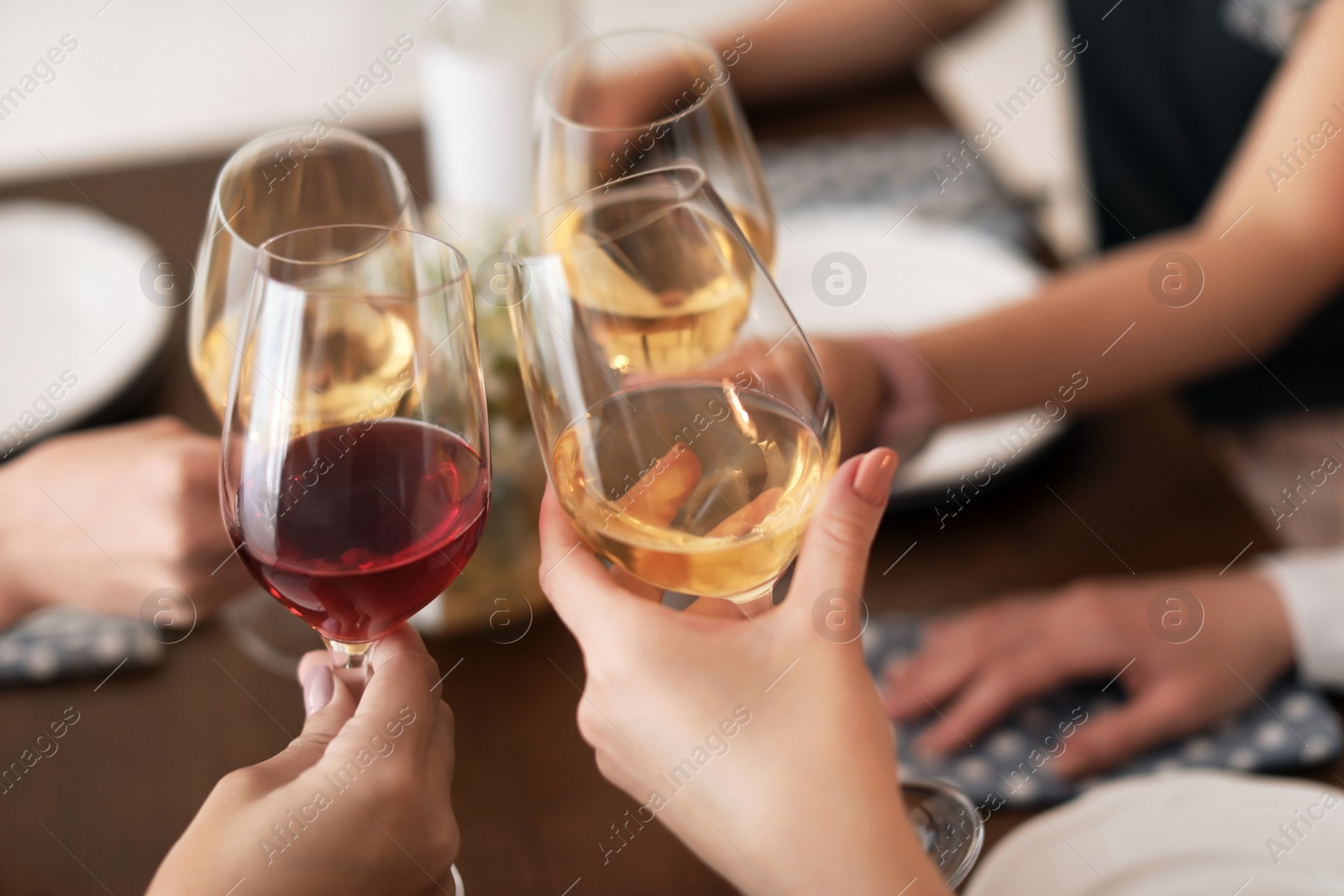 Photo of Young people with glasses of delicious wine at table