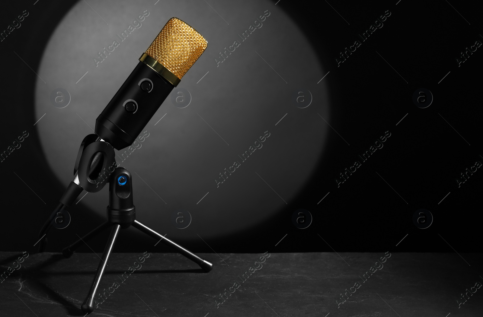 Photo of Stand with microphone on grey textured table, space for text. Sound recording and reinforcement