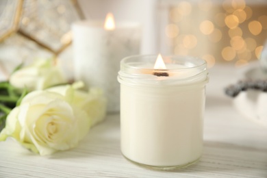 Photo of Burning candles in holders on white table