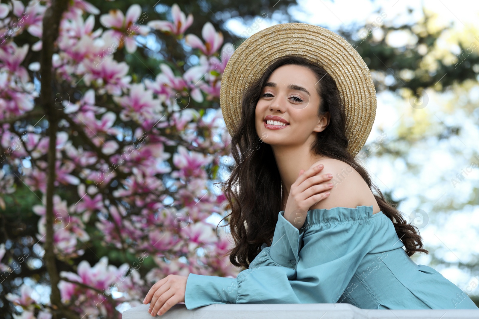 Photo of Beautiful woman near blossoming magnolia tree on spring day