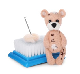 Needle felted bear, wool and tools isolated on white
