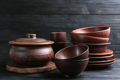 Photo of Set of clay utensils on black wooden table