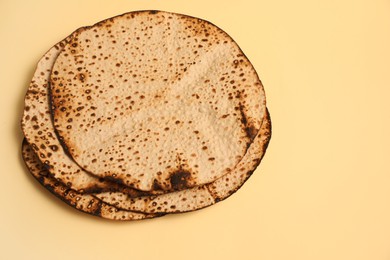 Photo of Tasty matzos on beige background, above view. Passover (Pesach) celebration