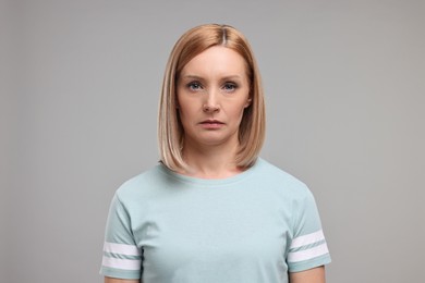 Photo of Portrait of sad woman on grey background