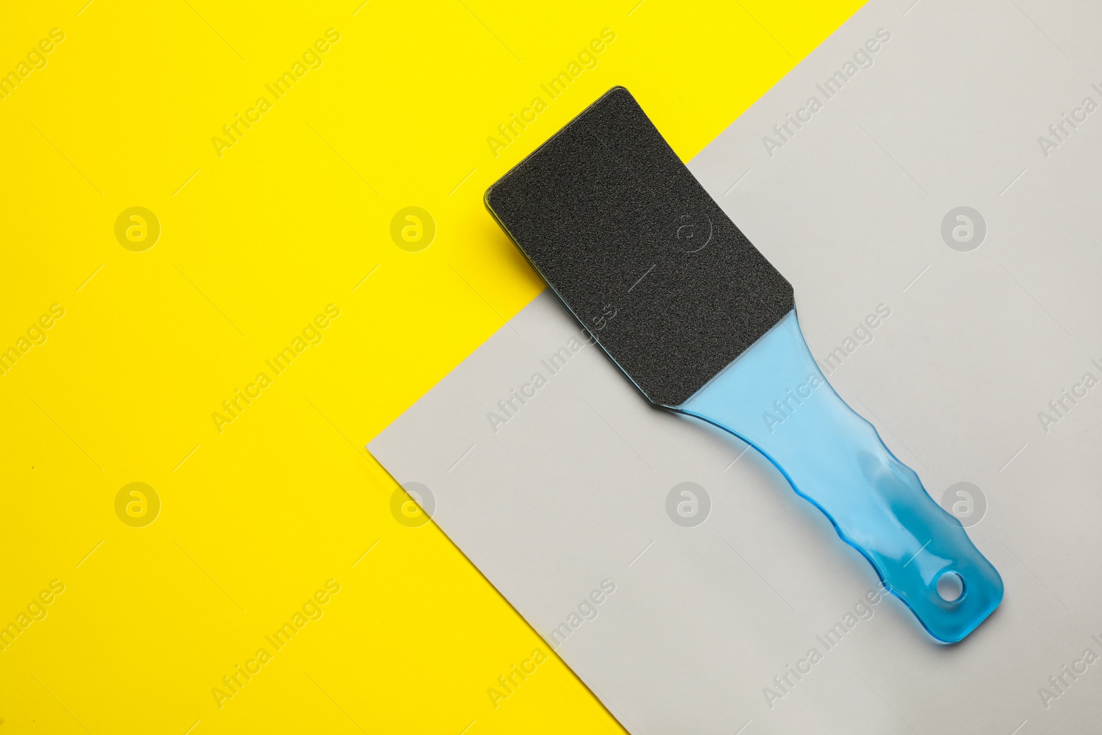 Photo of Blue foot file on color background, top view with space for text. Pedicure tool