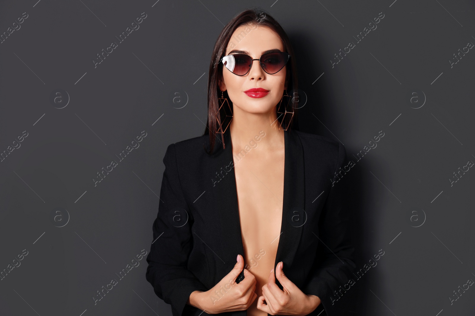 Photo of Beautiful woman wearing jacket and sunglasses on black background