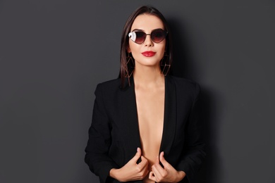 Photo of Beautiful woman wearing jacket and sunglasses on black background