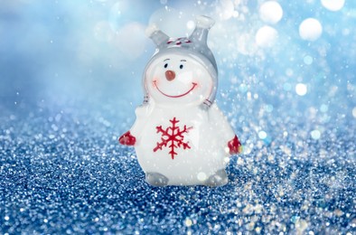 Image of Cute decorative snowman on shiny glitter, bokeh effect