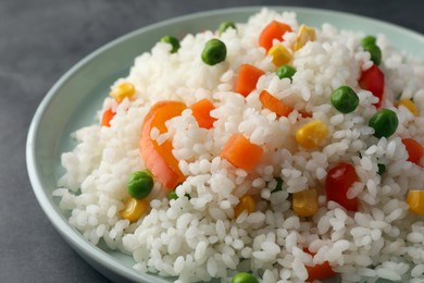Photo of Delicious rice with vegetables on grey table, closeup