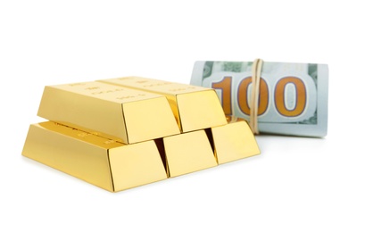 Shiny gold bars and dollar bills on white background