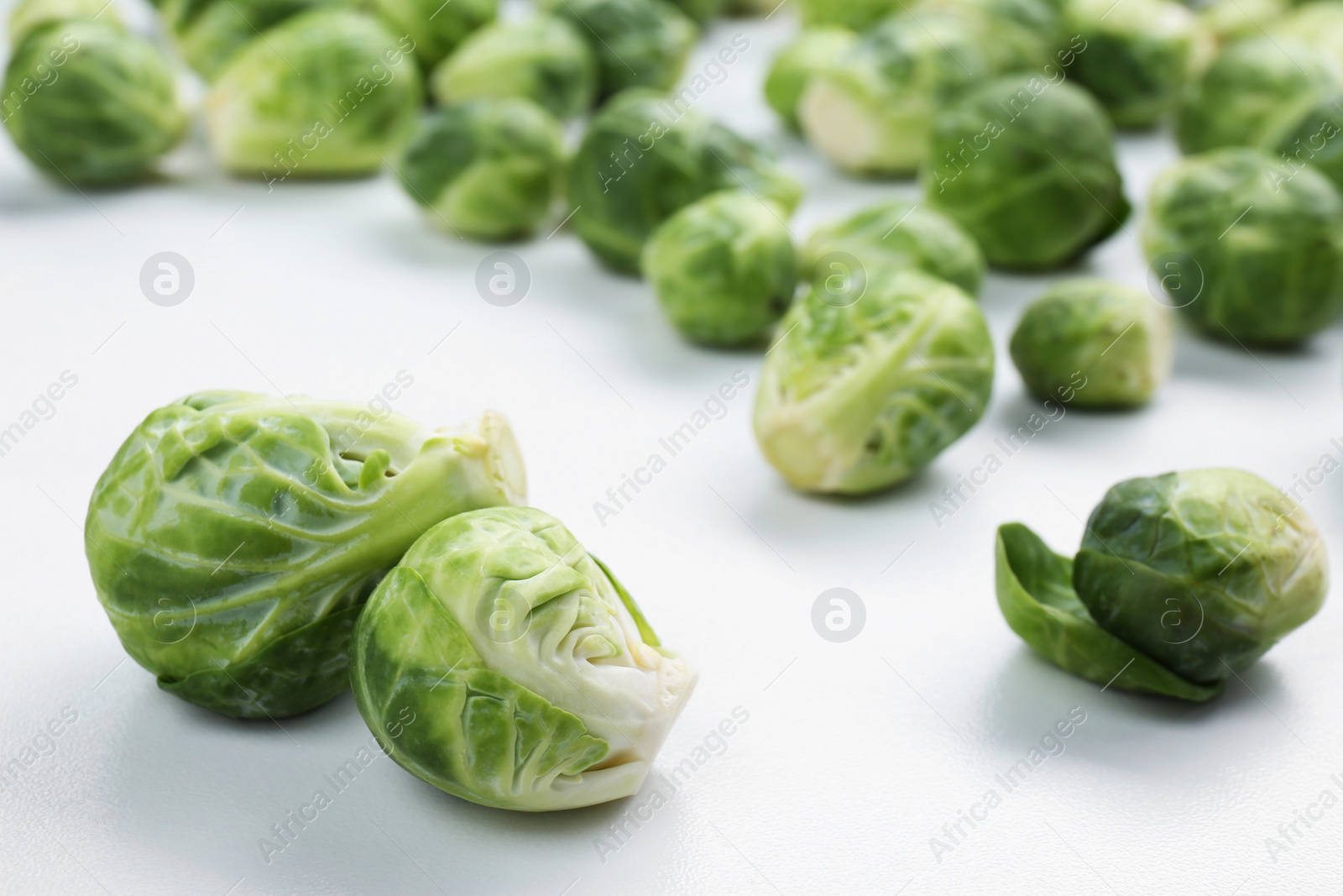 Photo of Fresh Brussels sprouts on white table, closeup