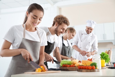 Group of people and male chef at cooking classes