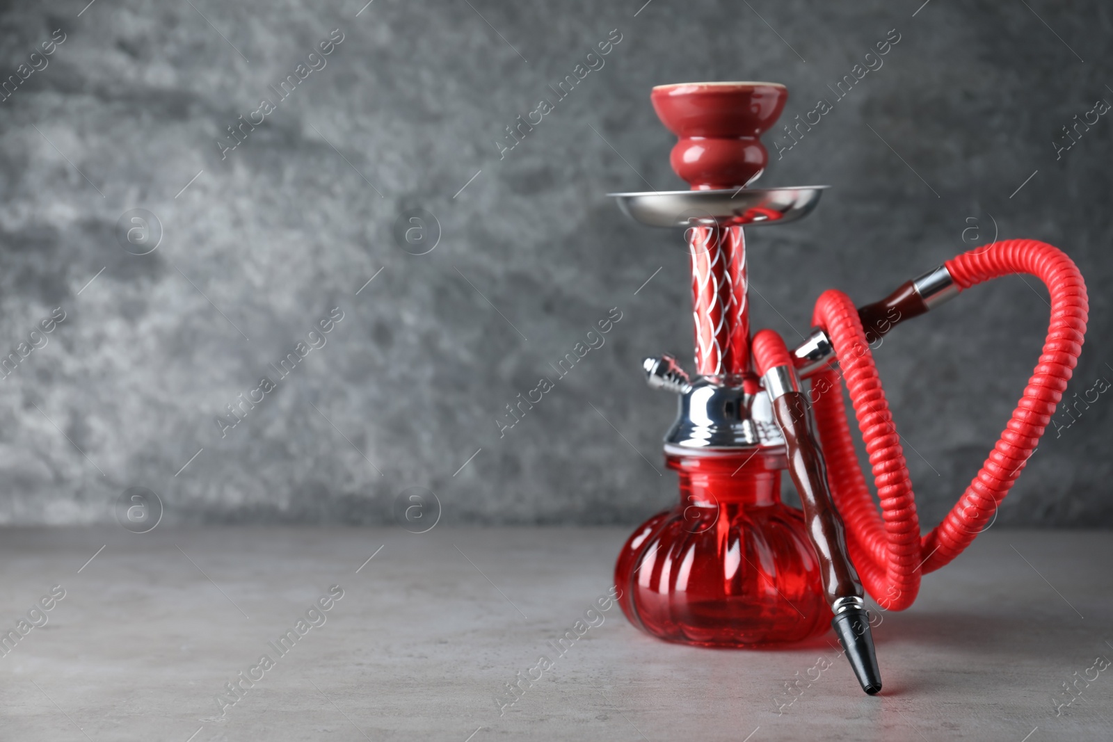 Photo of Modern red hookah on grey table, space for text