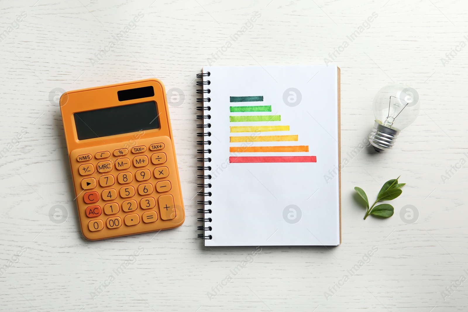 Photo of Flat lay composition with energy efficiency rating chart, light bulb and calculator on white wooden background