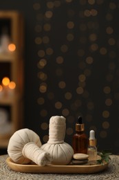 Photo of Spa composition. Herbal sacks, cosmetic products and stones on table indoors. Space for text