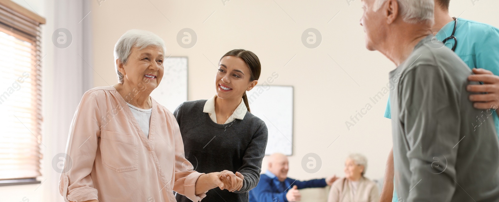 Image of Care workers helping to elderly patients to walk in geriatric hospice. Banner design