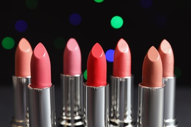 Different lipsticks against blurred lights. Cosmetic product