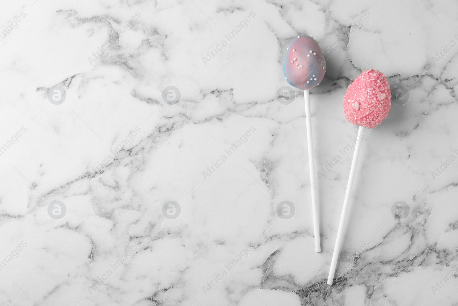 Photo of Egg shaped cake pops and space for text on white marble table, flat lay. Easter celebration