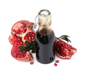 Photo of Tasty pomegranate sauce in bottle, fruits and branch isolated on white