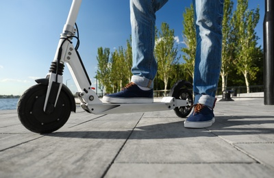 Photo of Man with kick scooter on city street, closeup