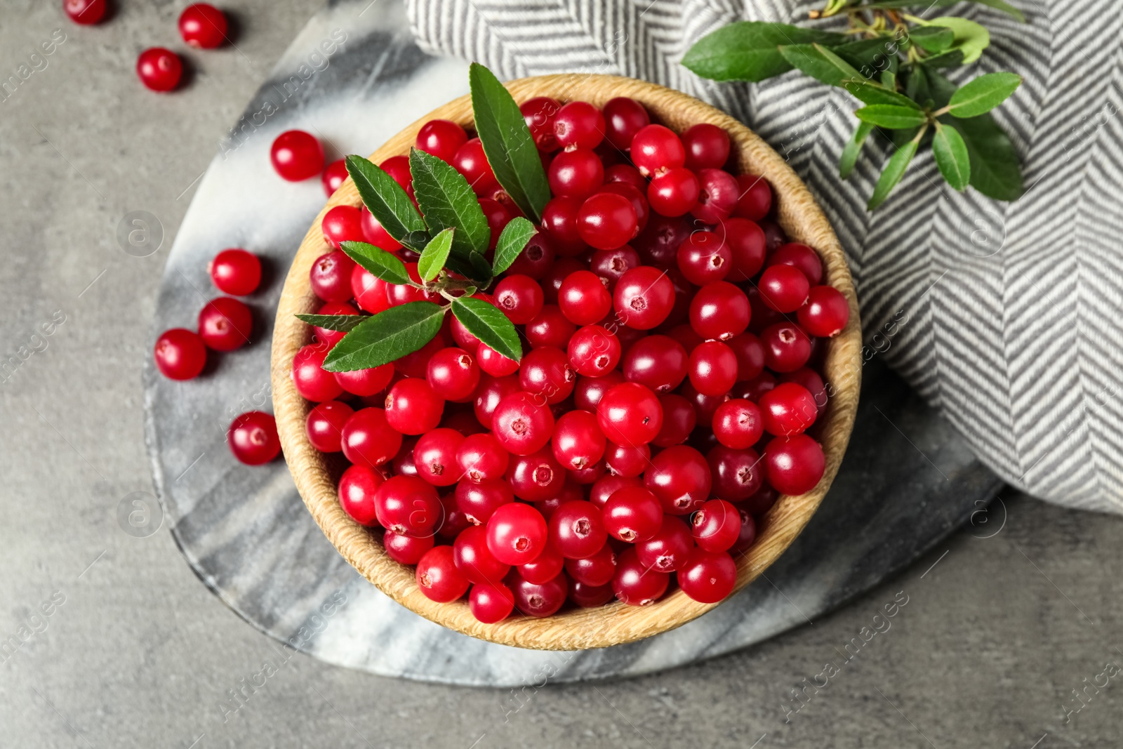 Photo of Tasty ripe cranberries on grey table, flat lay