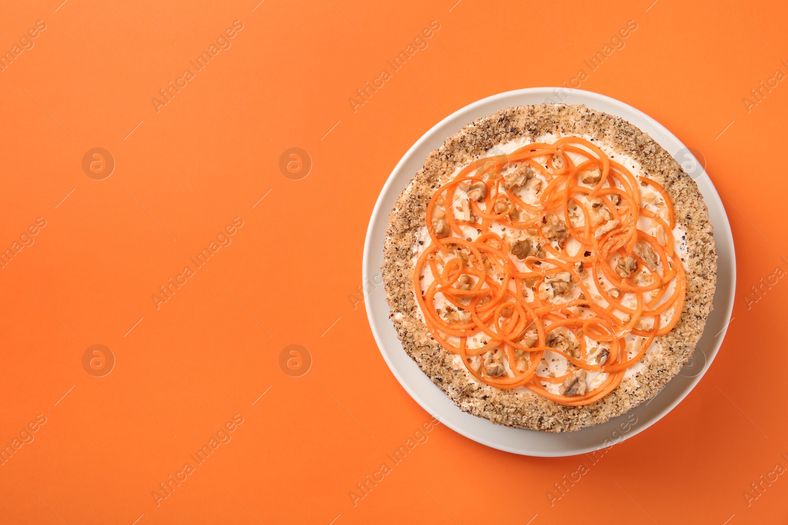 Photo of Dish with delicious carrot cake on color background, top view. Space for text