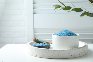 Photo of Blue sea salt on white table indoors, space for text