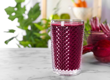 Photo of Glass with fresh beet juice on table