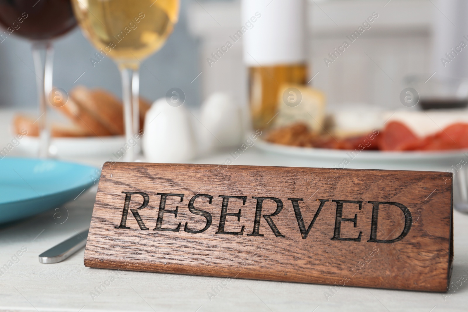 Photo of Table setting with RESERVED sign in restaurant