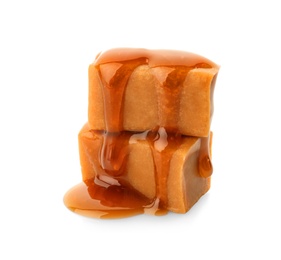 Delicious candies with caramel sauce on white background