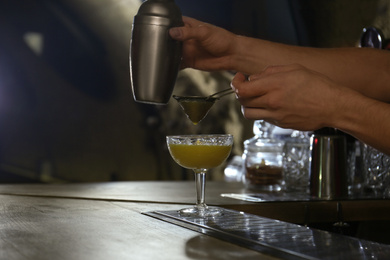 Photo of Bartender preparing fresh alcoholic cocktail at bar counter, closeup