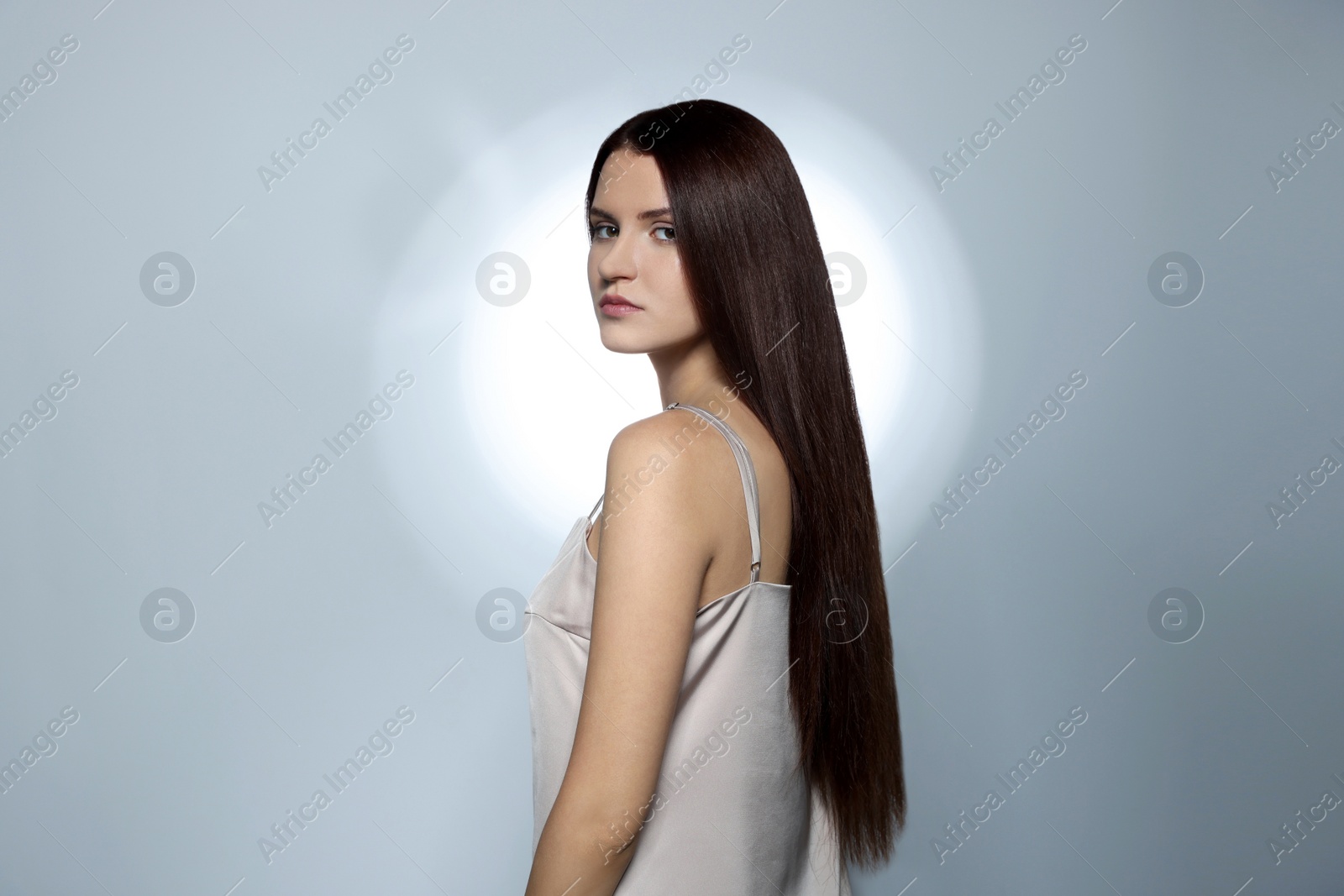 Photo of Beautiful young woman with healthy strong hair posing in studio, space for text