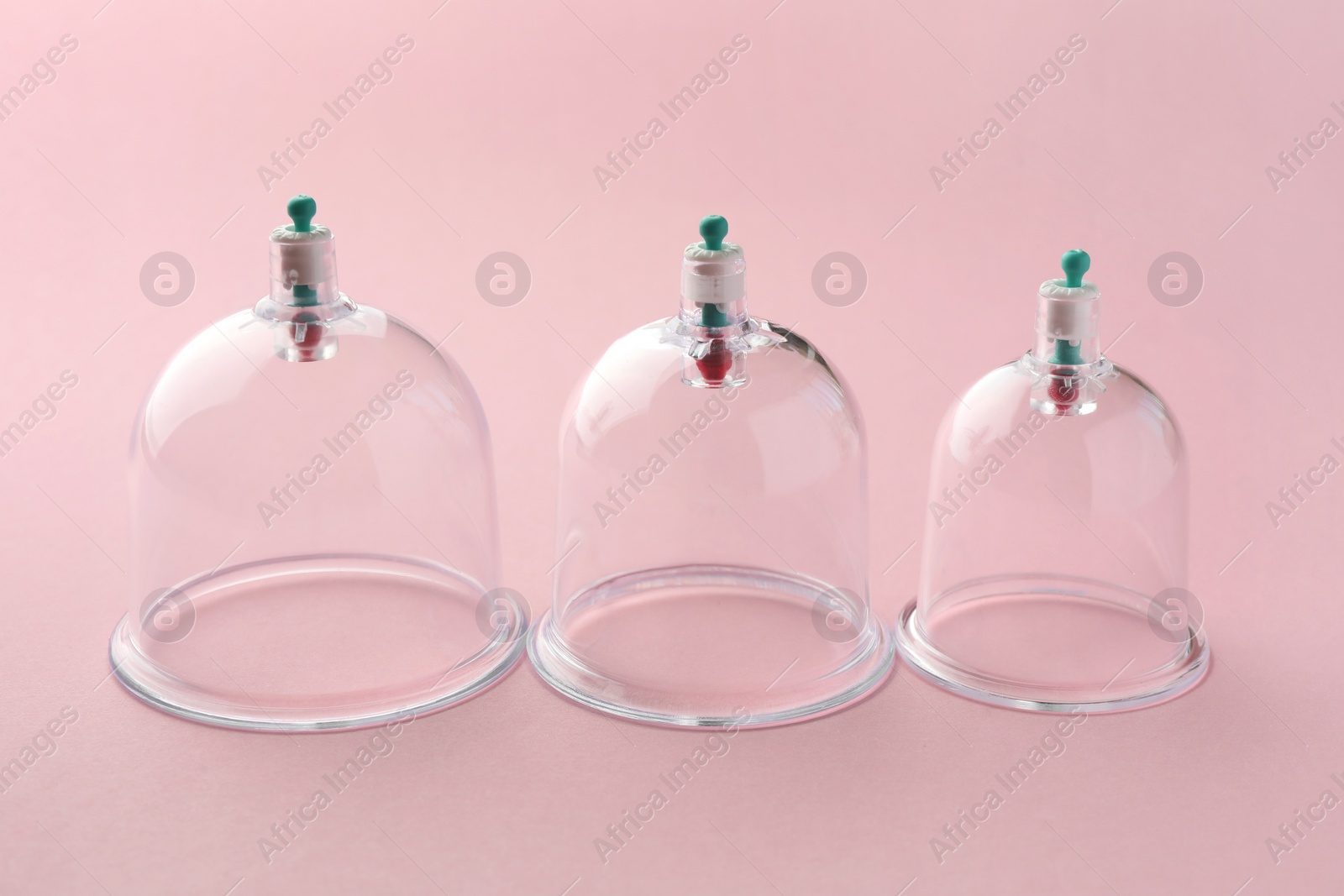 Photo of Plastic cups on pink background. Cupping therapy