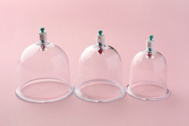 Photo of Plastic cups on pink background. Cupping therapy