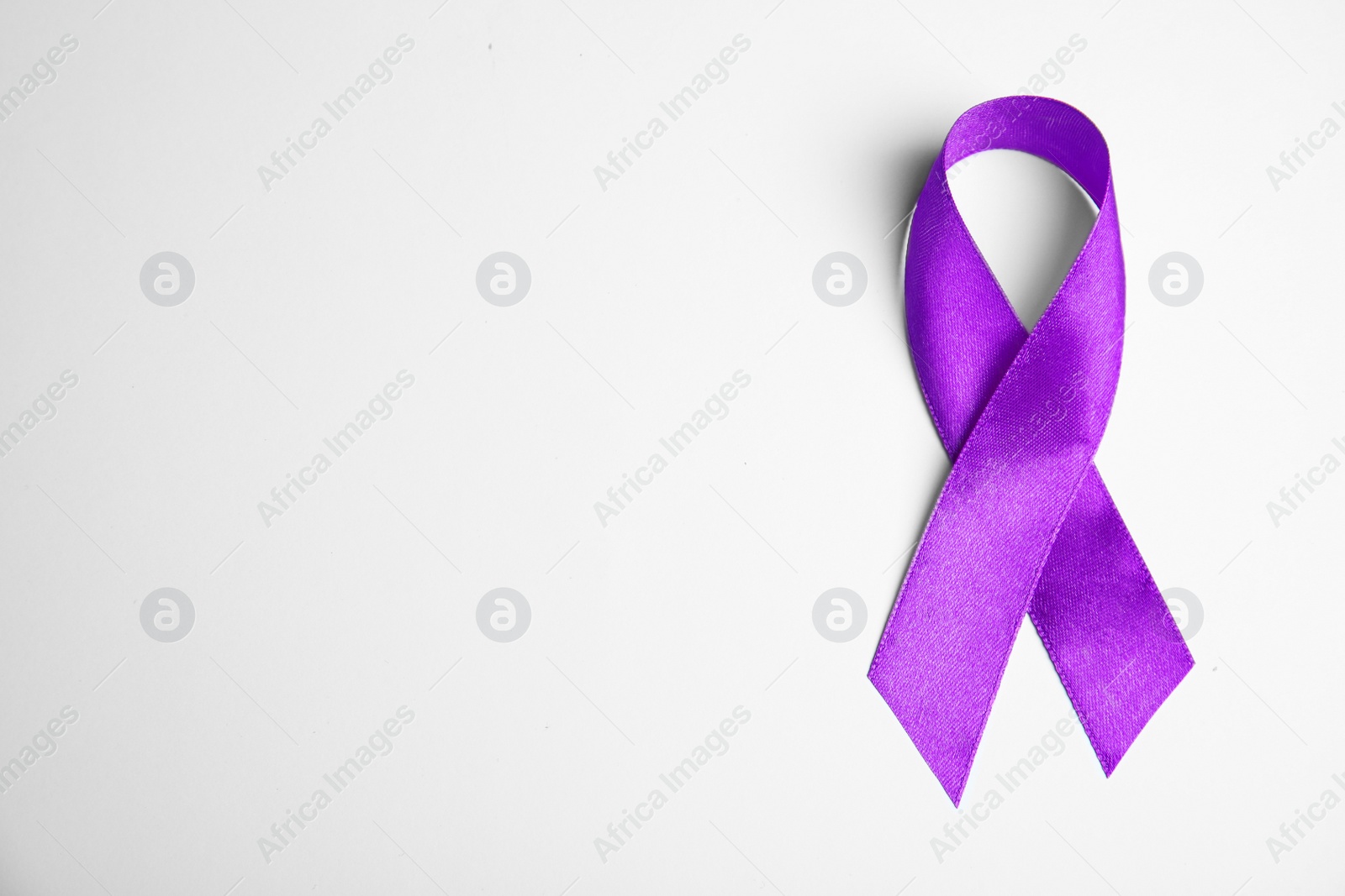 Photo of Purple ribbon on white background, top view. Domestic violence awareness