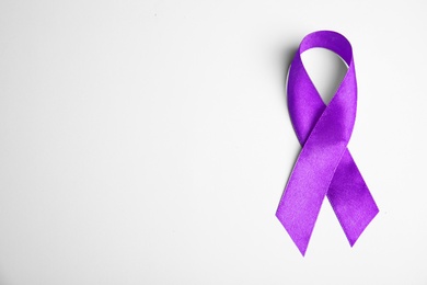 Purple ribbon on white background, top view. Domestic violence awareness