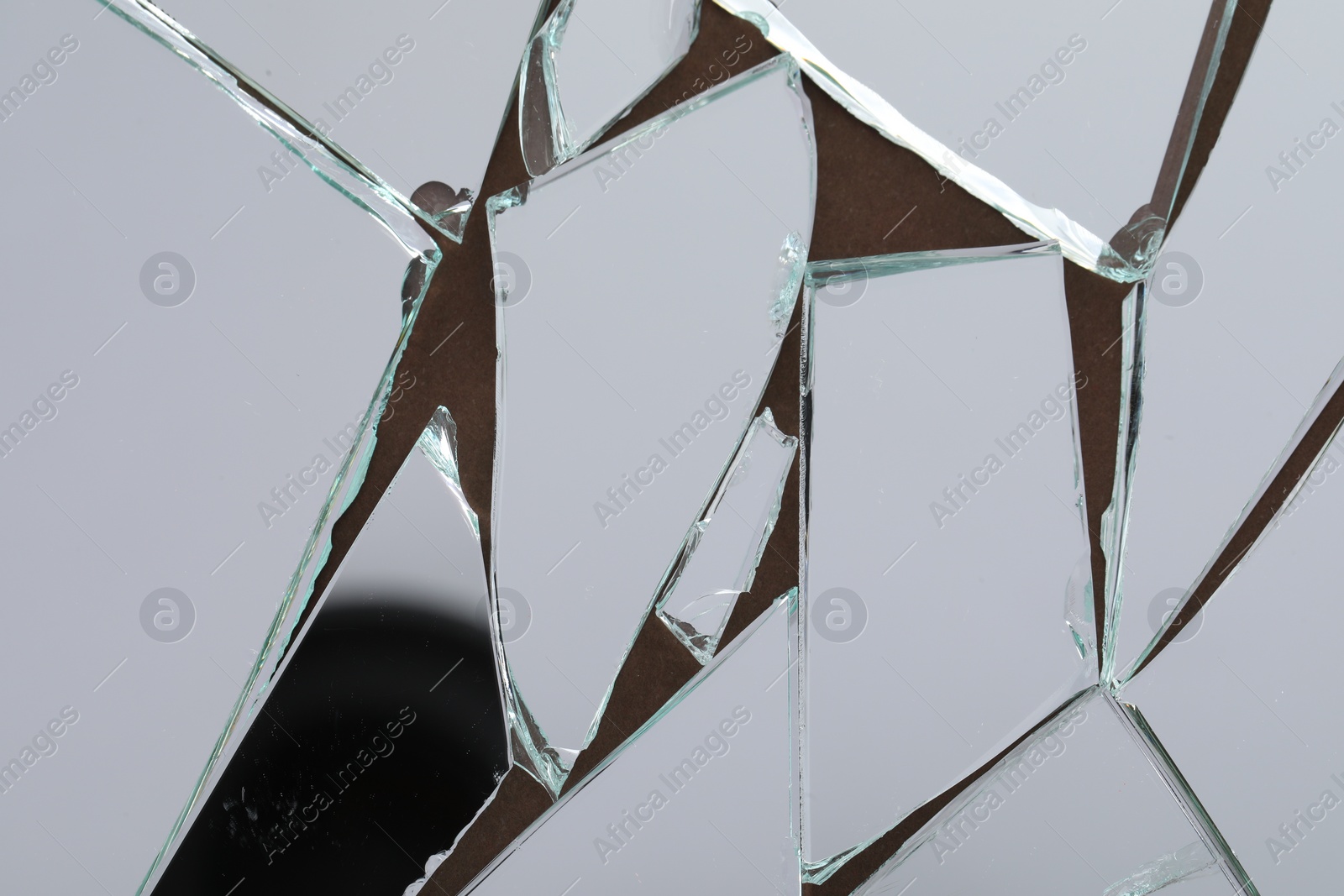 Photo of Shards of broken mirror on backing board, top view