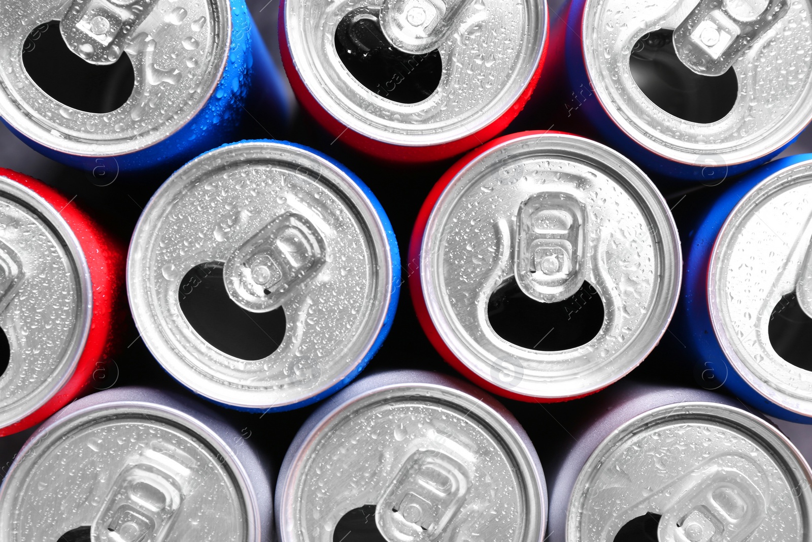 Photo of Energy drinks in wet cans as background, top view. Functional beverage