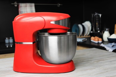 Modern stand mixer on wooden table in kitchen. Space for text