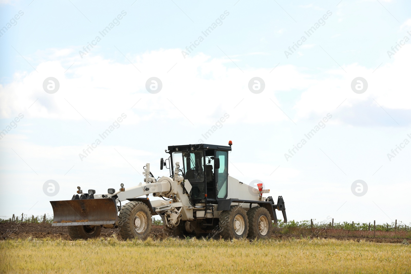 Photo of Modern agricultural machinery in field on sunny day