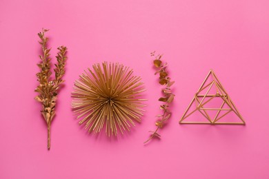 Flat lay composition with golden decor elements on pink background